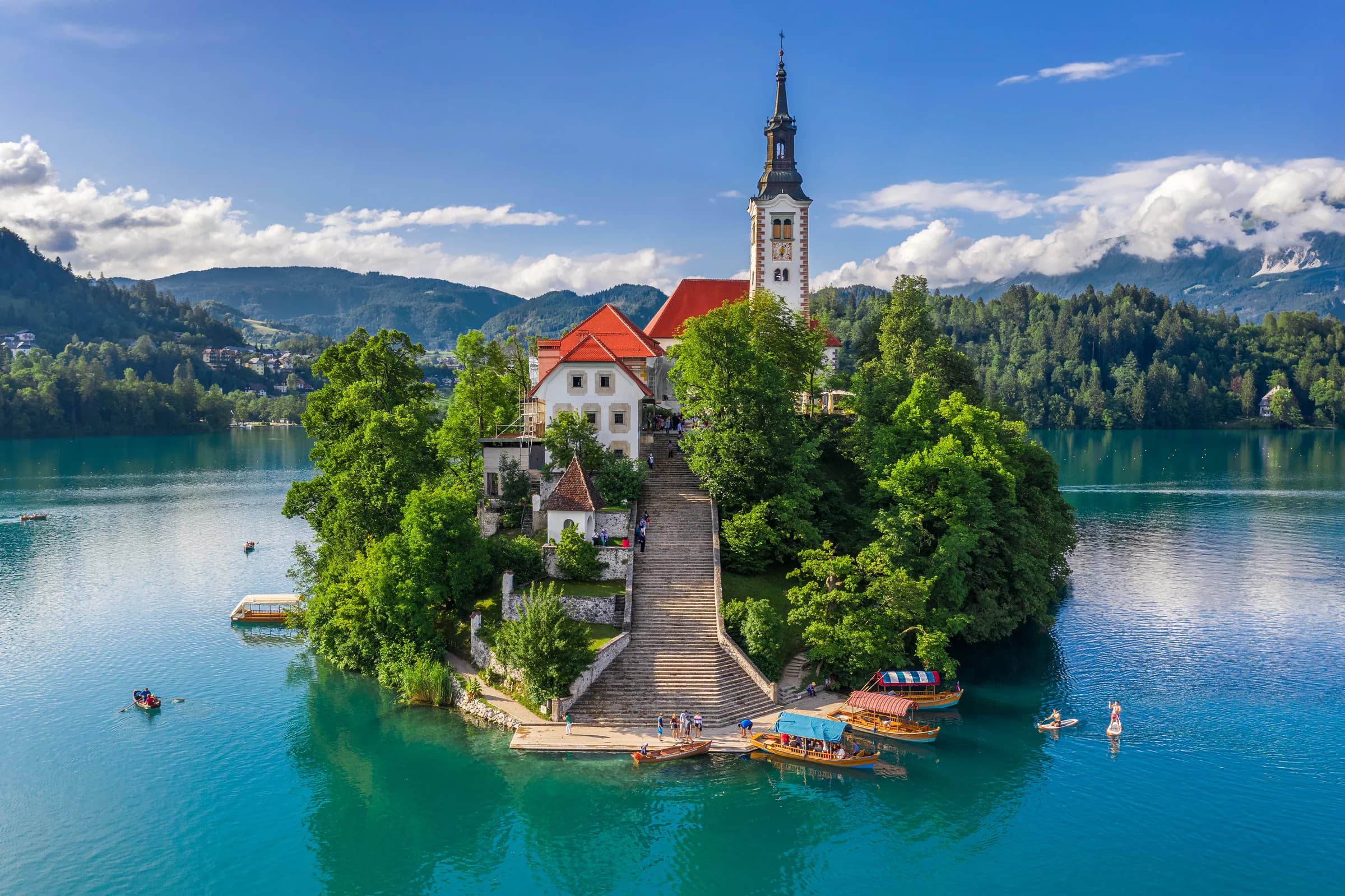 Bled's island church and stone stairway surrounded by blue lake water.