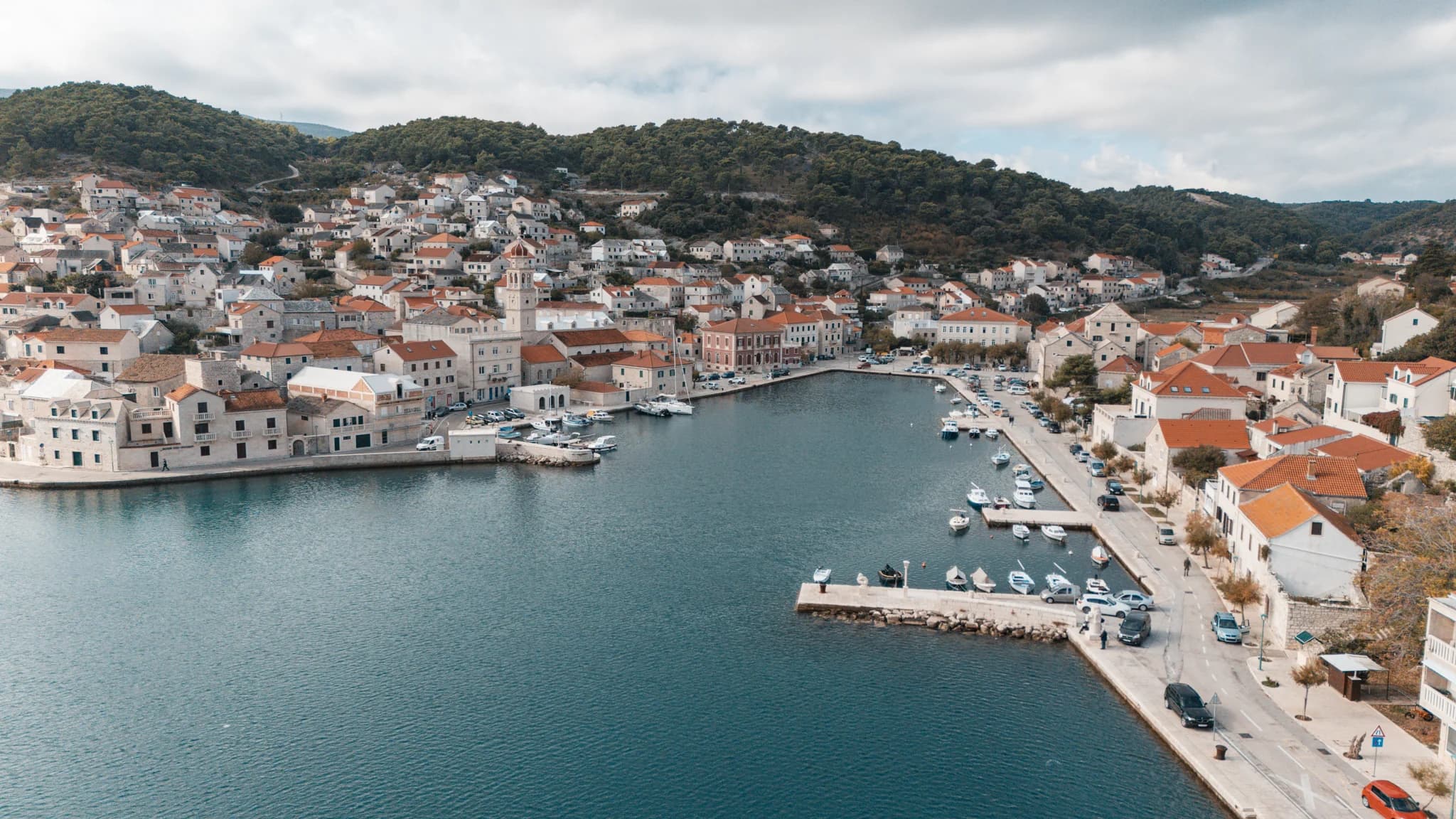 Stone houses and a waterfront surrounding a narrow harbour on Brač.