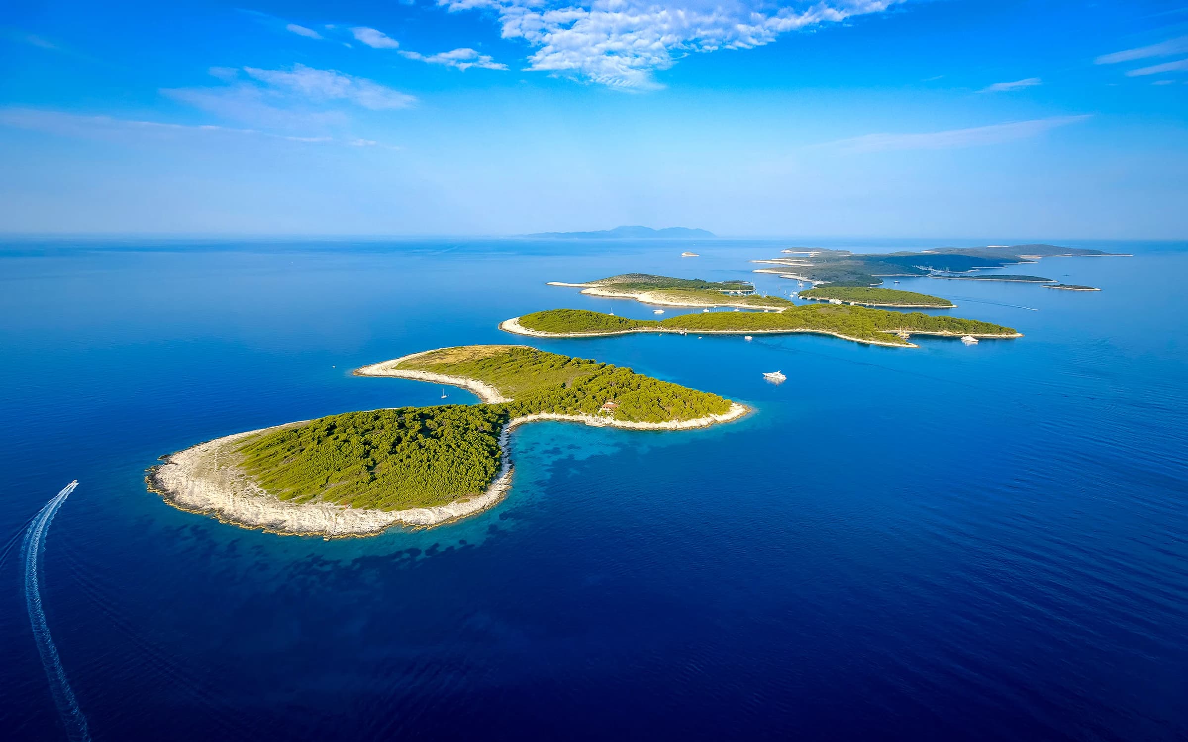 The wooded Pakleni Islands stretching across blue water, seen from above.