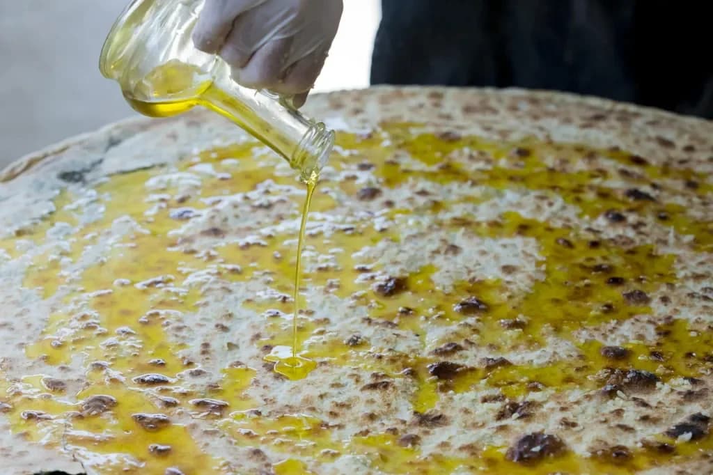 Fresh soparnik being finished with olive oil.
