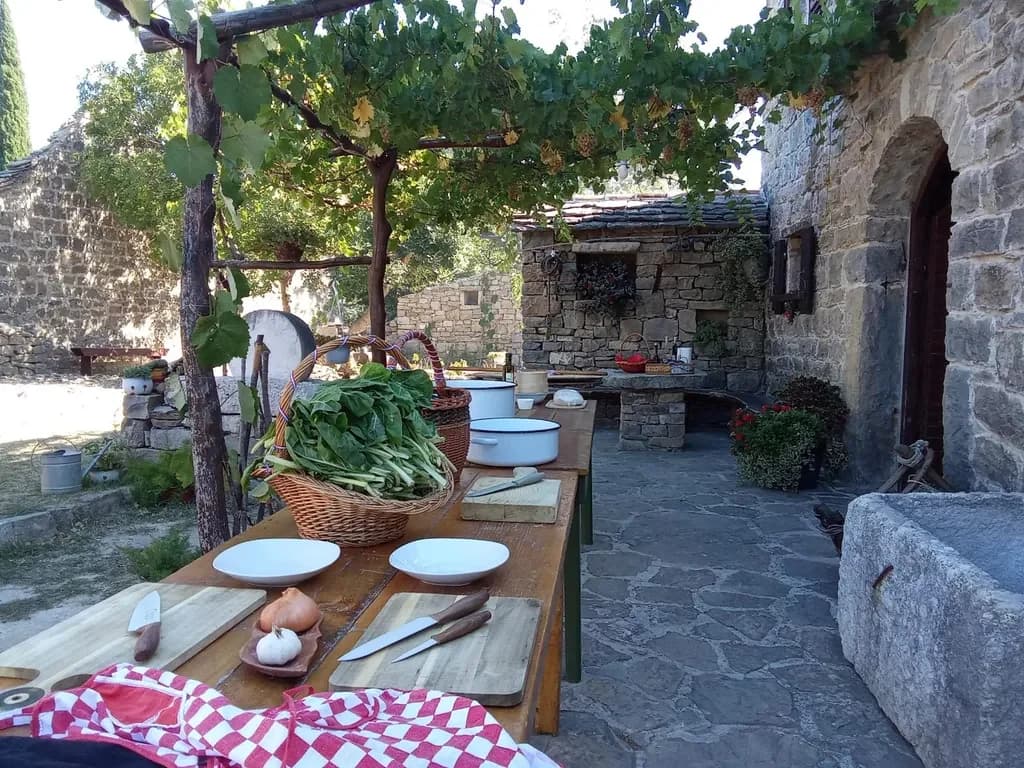 Ingredients and bowls laid out for a soparnik workshop in a stone courtyard.
