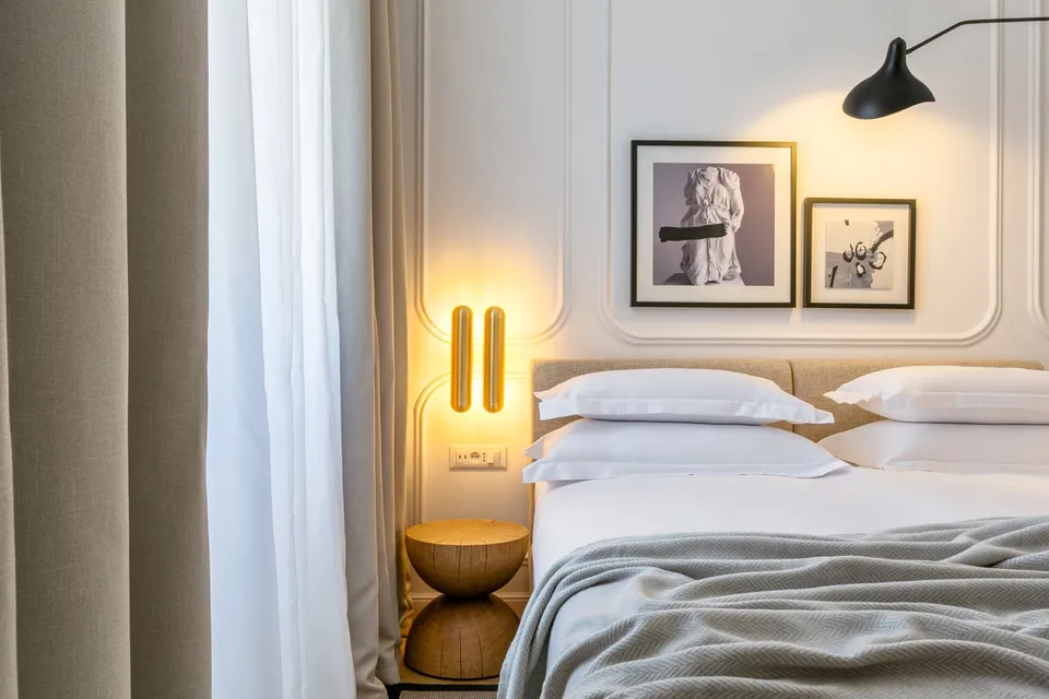 A guest room at Heritage Hotel Fermai in Split, with a double bed and framed artwork.